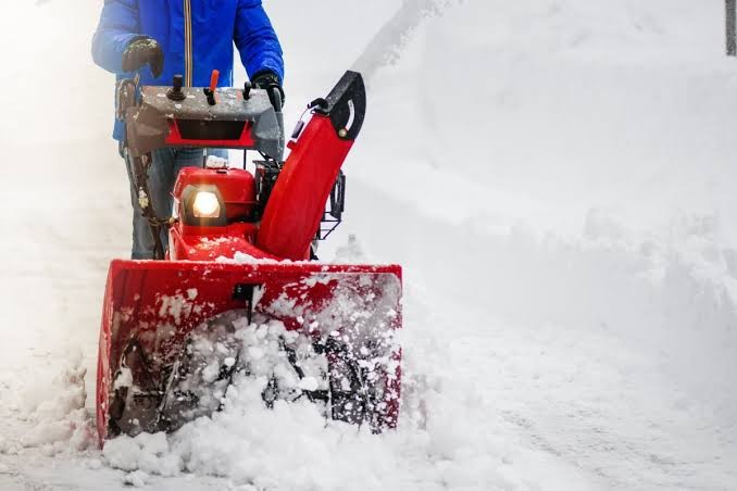 Residential snow blowing on a snow-covered driveway